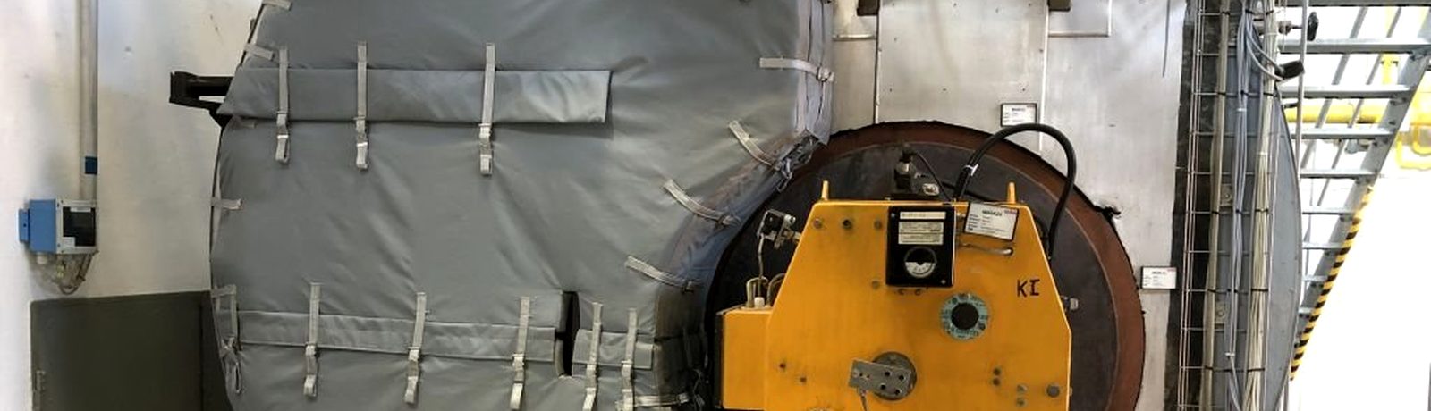 Maßgefertigte Isolierung an einem Industriekessel mit Brenner – Arbeit einer Isolierung-Firma