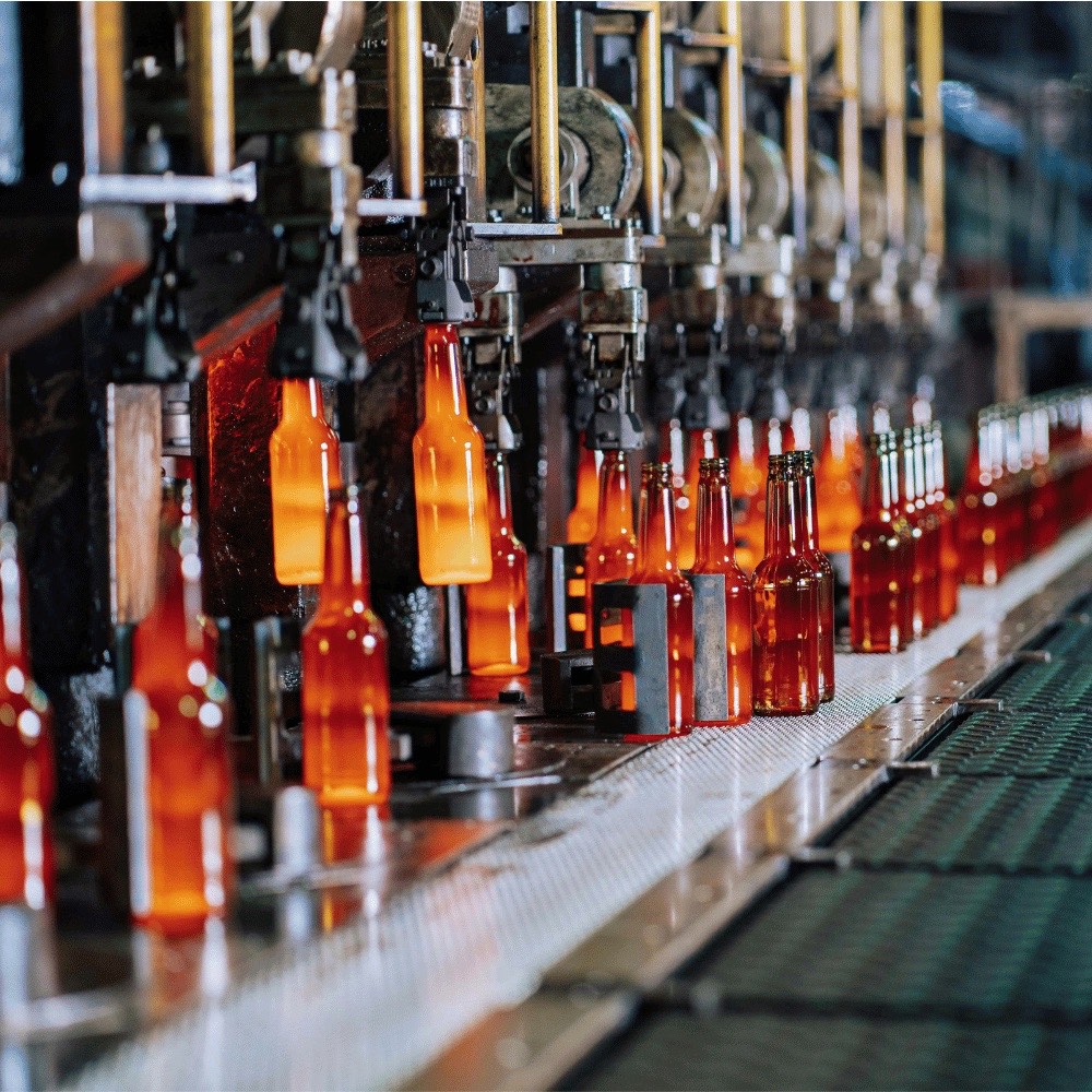 Braune Glasflaschen auf einer Abfüllanlage in der Getränkeproduktion – hygienische Isolierungen für die Getränkeindustrie
