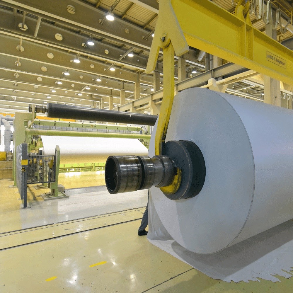 Große Papierrolle an einer Papiermaschine in heller Produktionshalle – Wärmedämmungen für die Papierherstellung