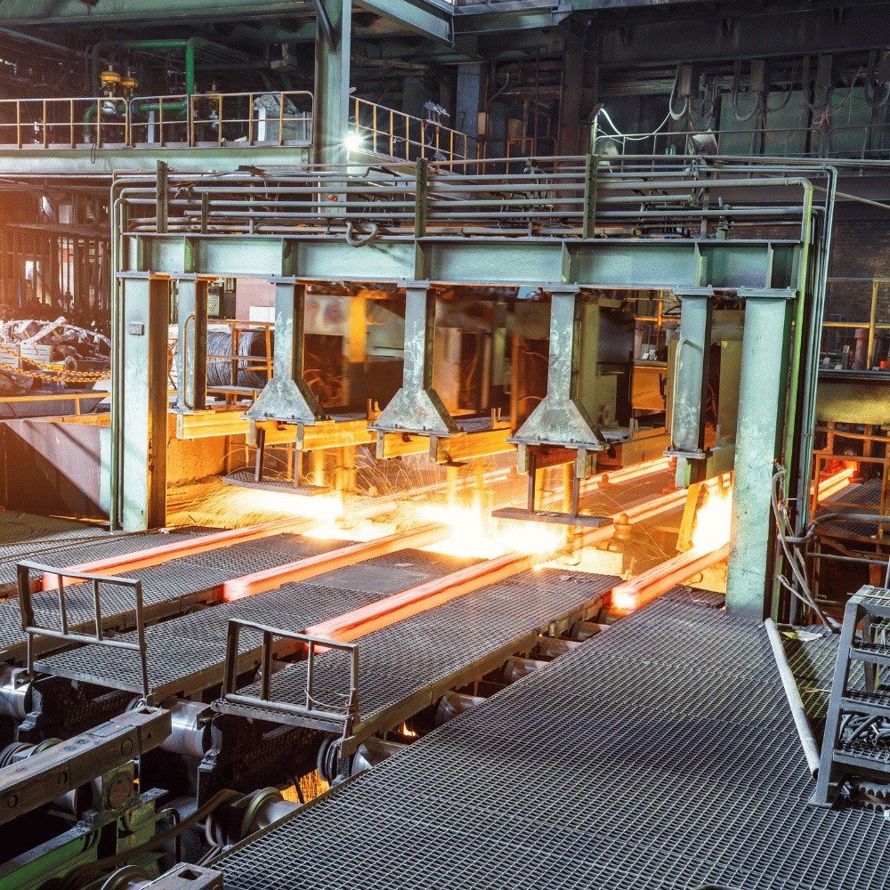 Glühende Stahlbrammen laufen durch ein Walzwerk – robuste Isolierungen für Stahl- und Betonverarbeitung