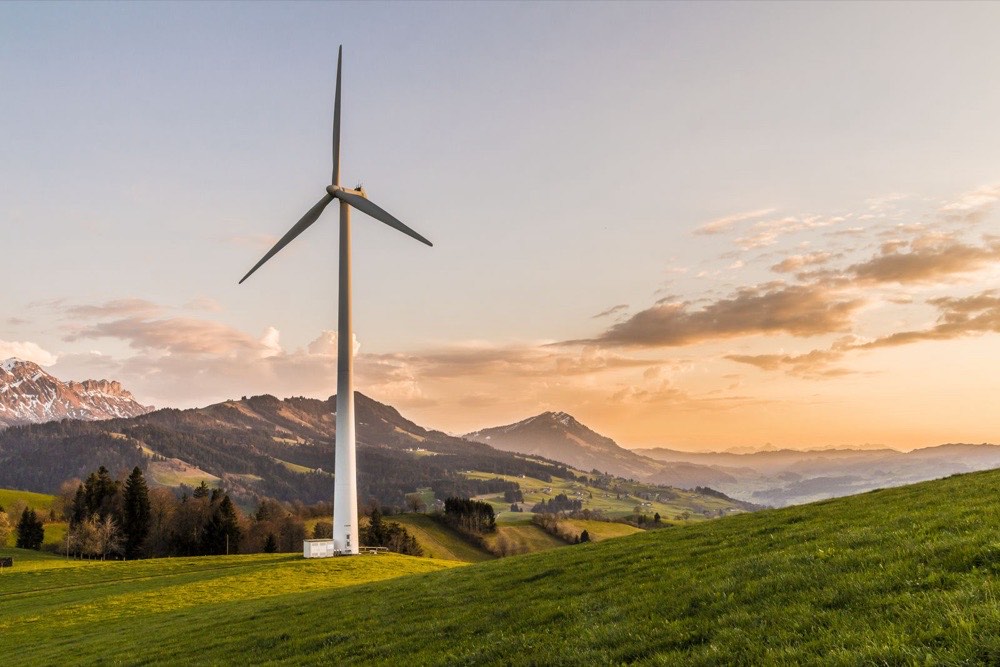 Windkraftanlage auf grüner Anhöhe bei Sonnenuntergang – Isolierungen für Turbinen und Turbomaschinen